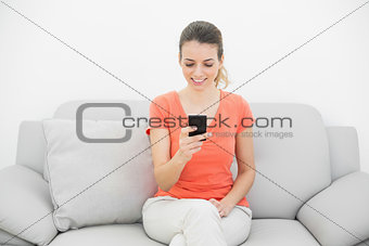 Happy gorgeous woman using her smartphone cheerfully