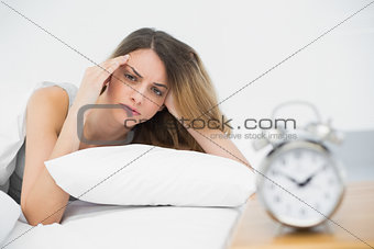 Exhausted young woman lying under the cover on her bed