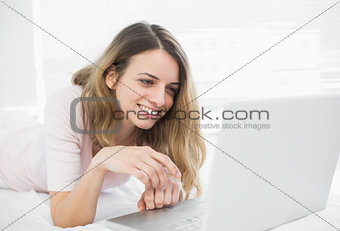 Attractive woman making smiling use of her notebook