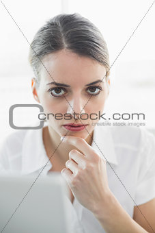 Calm thoughtful businesswoman looking at camera