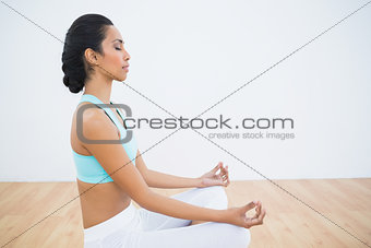 Attractive calm woman meditating sitting in lotus position