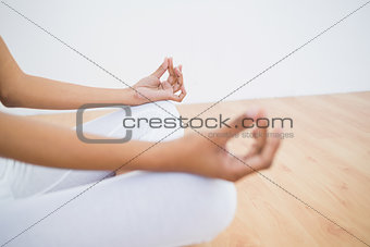 Mid section of slender young woman meditating