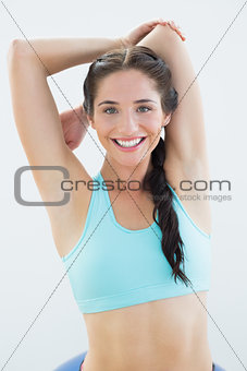 Sporty woman stretching hands behind back