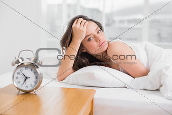 Portrait of a beautiful young woman lying in bed