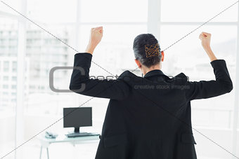 Businesswoman in suit clenching fist in office