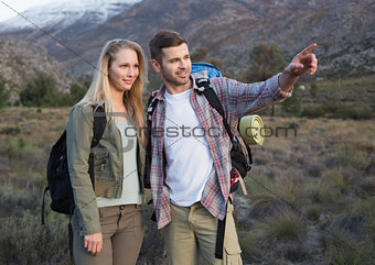 Couple with backpacks standing on landscape