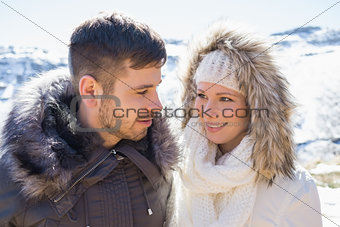Couple in fur hood jackets against snowed mountain