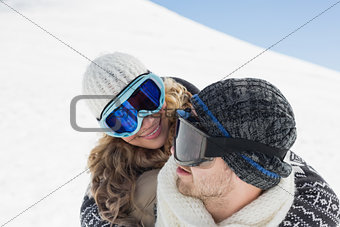 Close up of a couple in ski goggles against snow