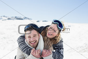 Cheerful couple with ski goggles on snow