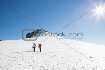 Skiers walking on snow on a sunny day