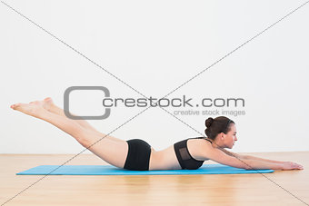 Sporty young woman doing the Locust Posture