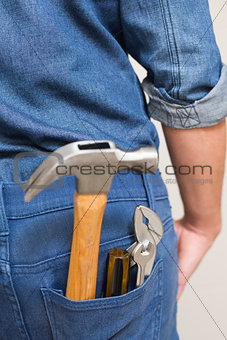 Several tools in a man's rear denim pocket