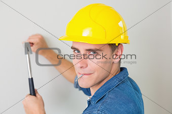 Close up of a handyman hammering nail in wall