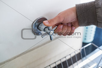 Plumber's hand opening a tap