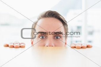 Portrait of businessman looking over blurred wall at office