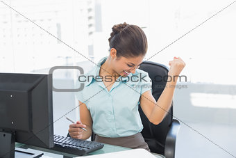 Happy businesswoman in front of computer in office