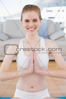 Toned woman in Namaste position at fitness studio