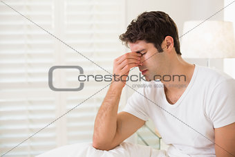 Side view of young man with eyes closed in bed