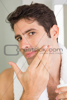 Man applying moisturizer on face