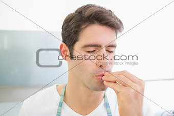 Close up of a young man with eyes closed kissing fingers