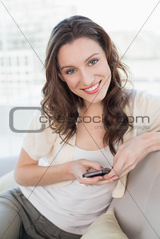 Portrait of relaxed young woman text messaging on sofa