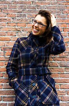 portrait of  young smiling woman on brick wall background