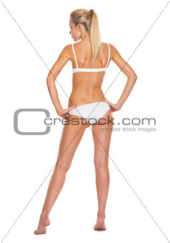 Full length portrait of young woman in lingerie . rear view
