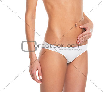 Closeup on young woman in lingerie checking body fat