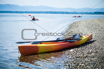Kayak on the Sea Shore with Kayakers in the Background