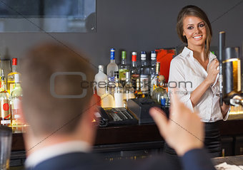 Handsome man ordering a drink from gorgeous waitress