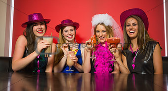 Happy friends at a hen night drinking cocktails