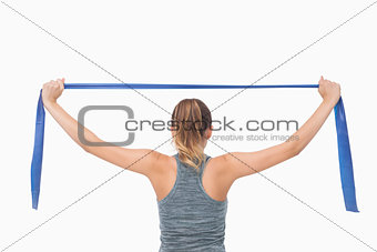 Ponytailed woman training with a resistance band