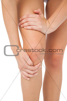 Close up of slim woman touching her injured knee