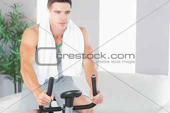 Determined handsome man exercising on exercise bike
