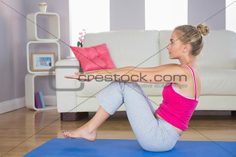 Sporty focused blonde doing core exercise