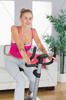 Sporty cheerful blonde training on exercise bike