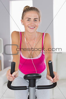 Portrait of sporty cheerful blonde training on exercise bike