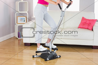 Sporty woman training on step machine