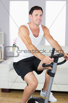 Smiling sporty man exercising on bike
