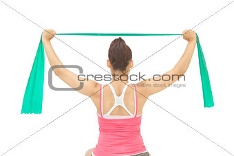 Sporty brunette stretching with resistance band