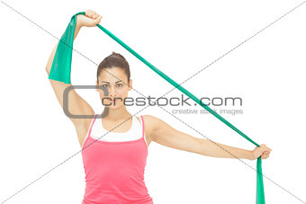 Cheerful sporty brunette stretching with resistance band