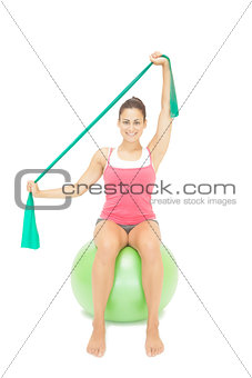Cheery sporty brunette stretching with resistance band