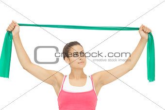 Calm sporty brunette stretching with resistance band