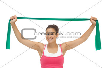 Pretty sporty brunette stretching with resistance band