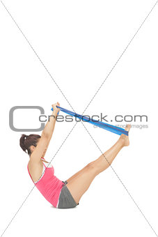 Attractive sporty brunette exercising with resistance band