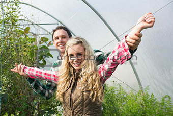 Young couple posing in a green house