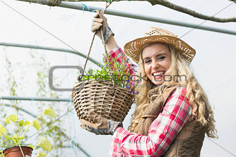 Pretty blonde showing a hanging flower basket