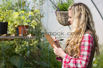 Blonde woman using a clipboard and taking notes