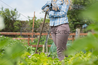 Young blonde woman standing in her garden