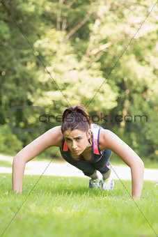 Focused fit woman doing plank position
